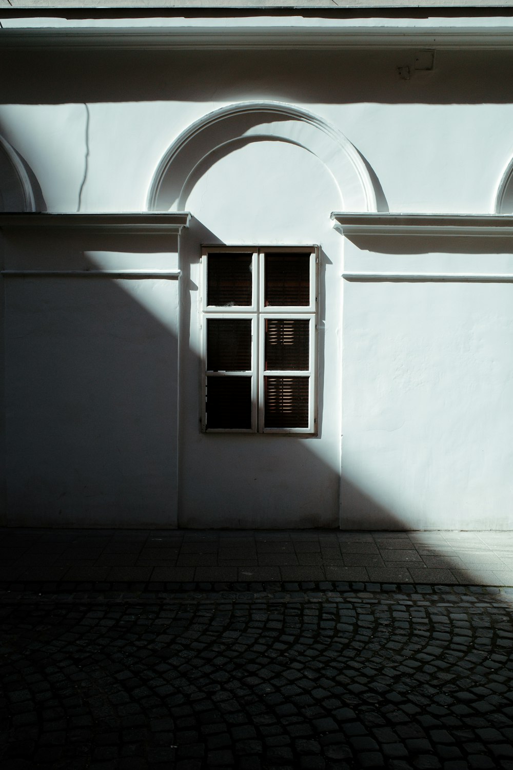 아치형 창문과 벽돌 보도가 있는 흰색 건물