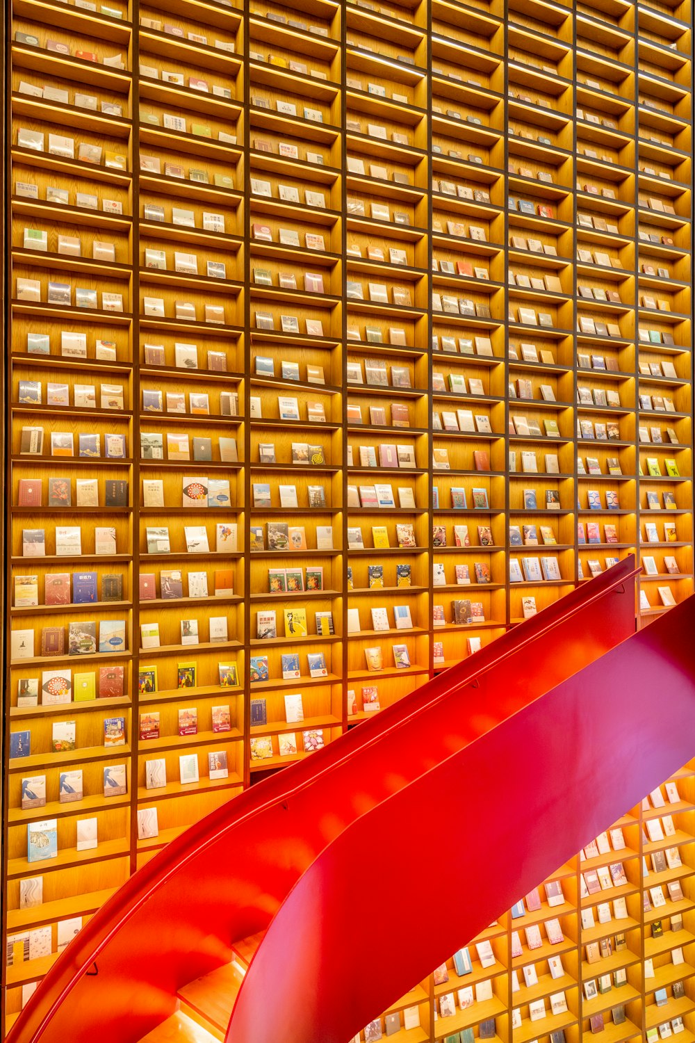 a red curved metal object in front of a wall of mail boxes