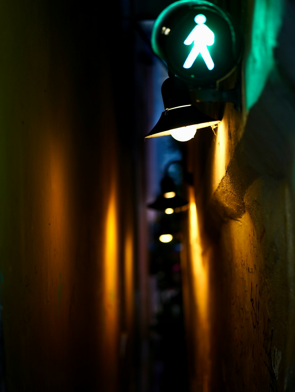 a green pedestrian sign on the side of a building