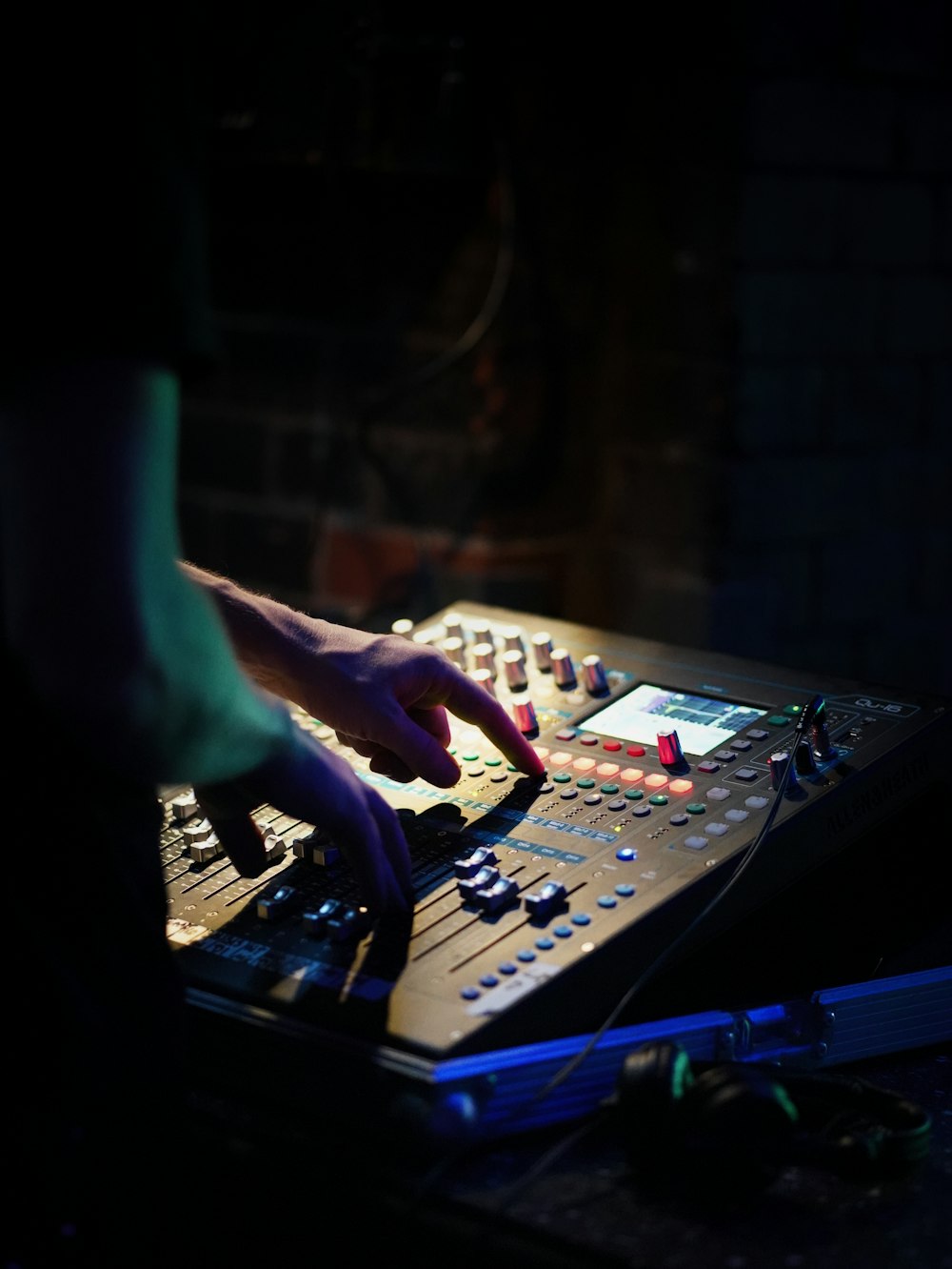 a person using a sound mixing console in a dark room