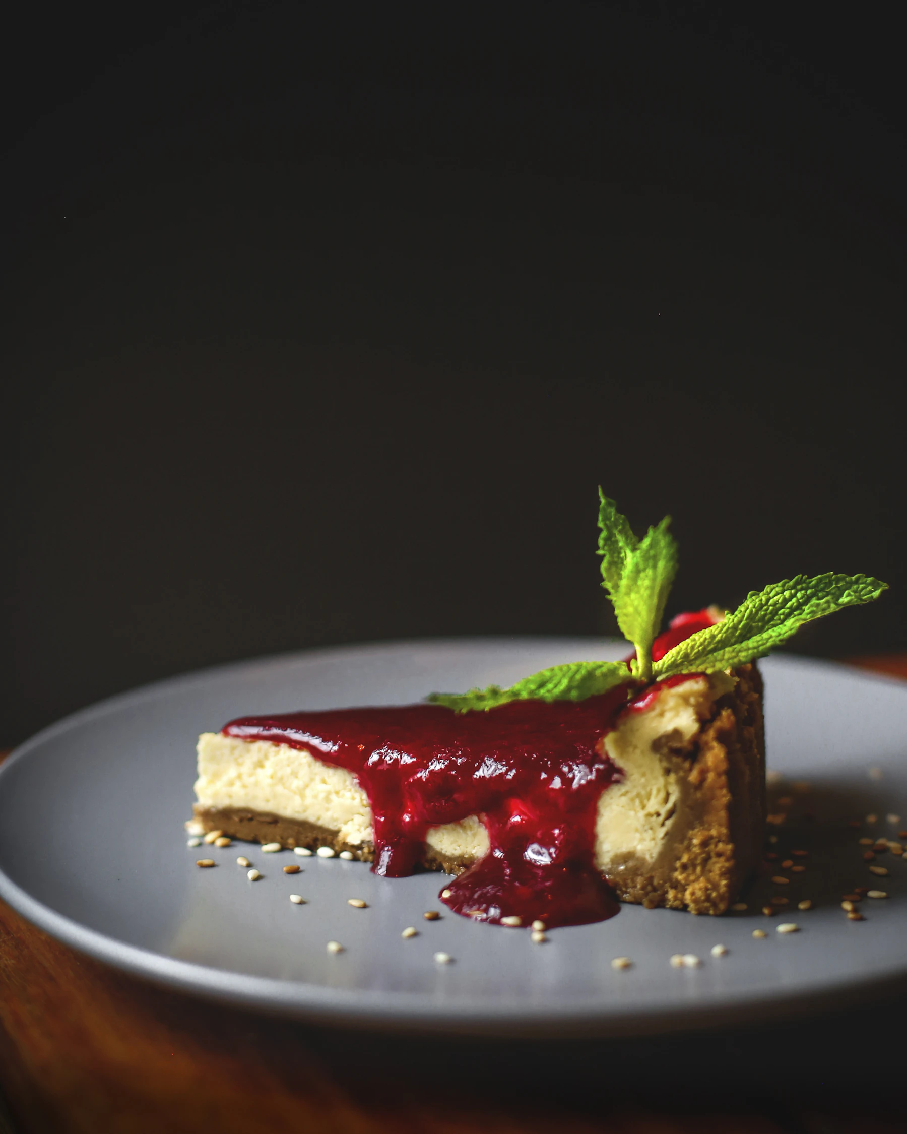 A slice of cheesecake with sauce and mint, hero shot
