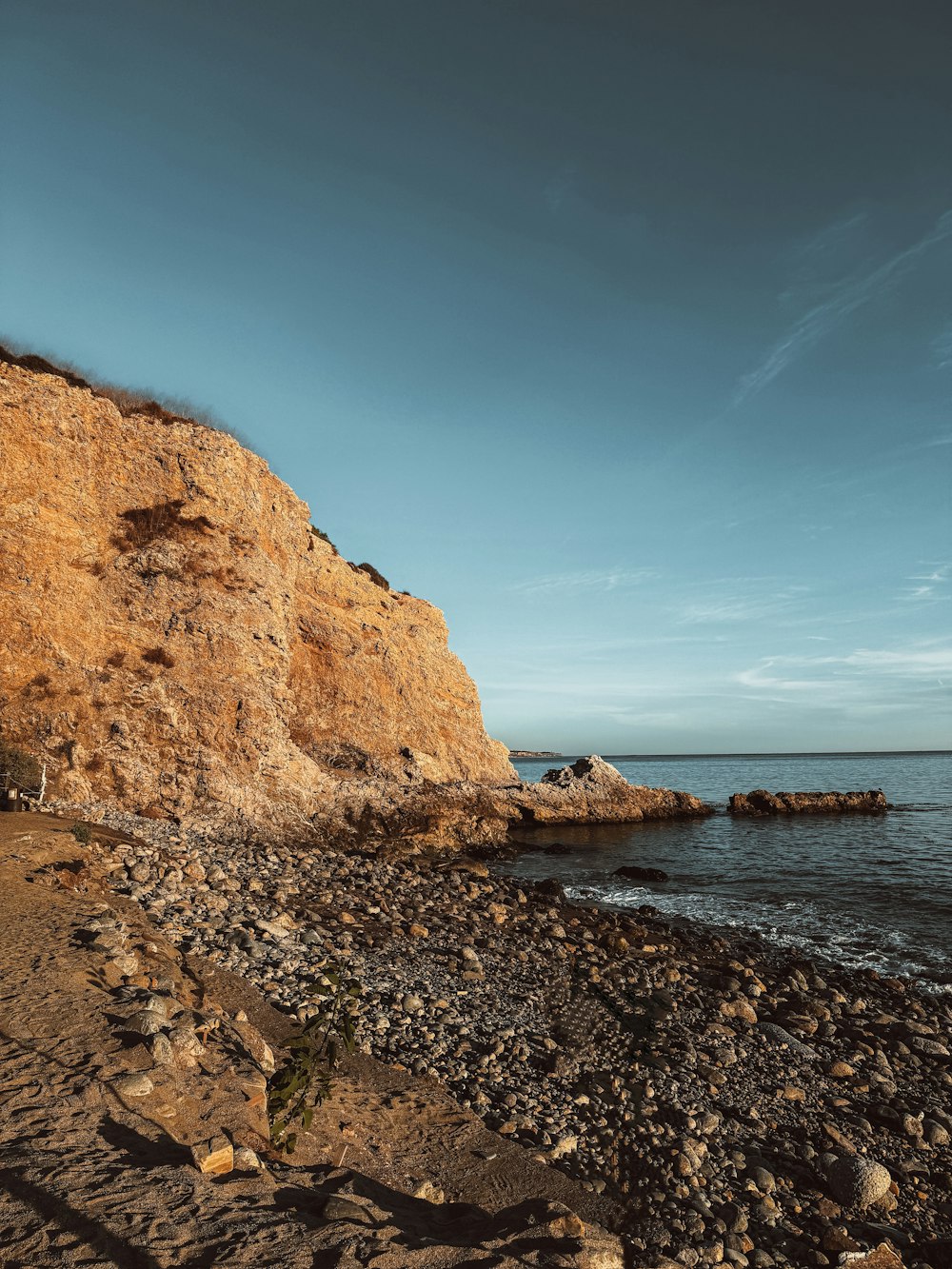 a man riding a surfboard on top of a rocky beach