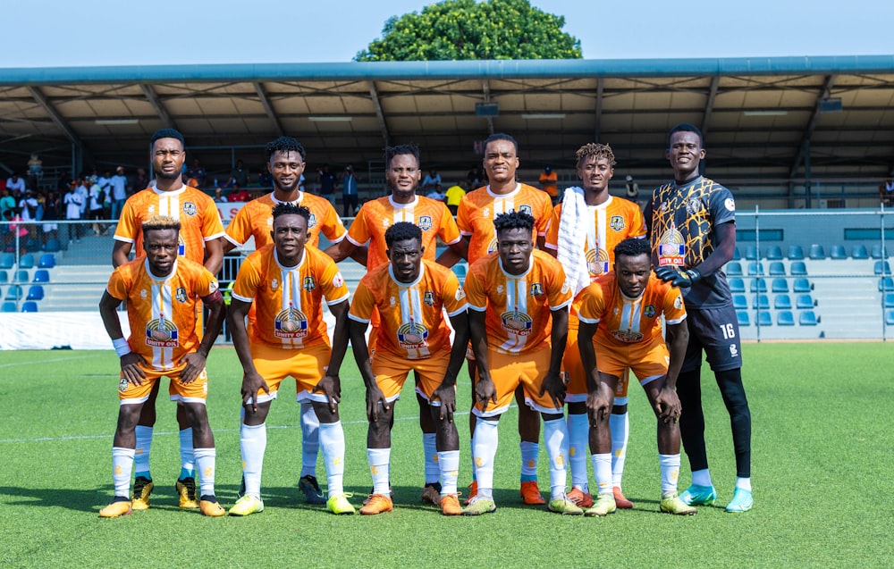 a group of men standing next to each other on a soccer field