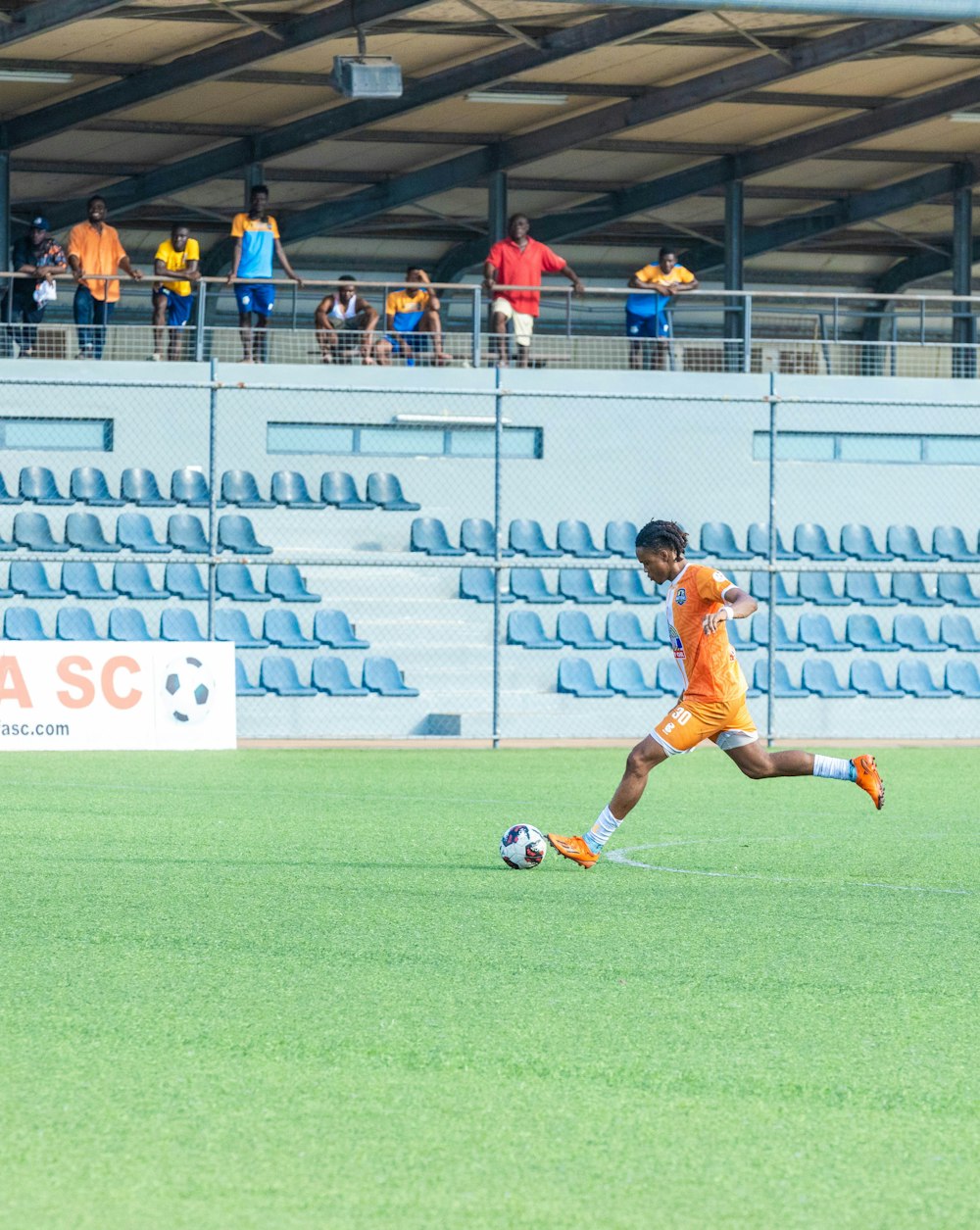 a soccer player is running with the ball