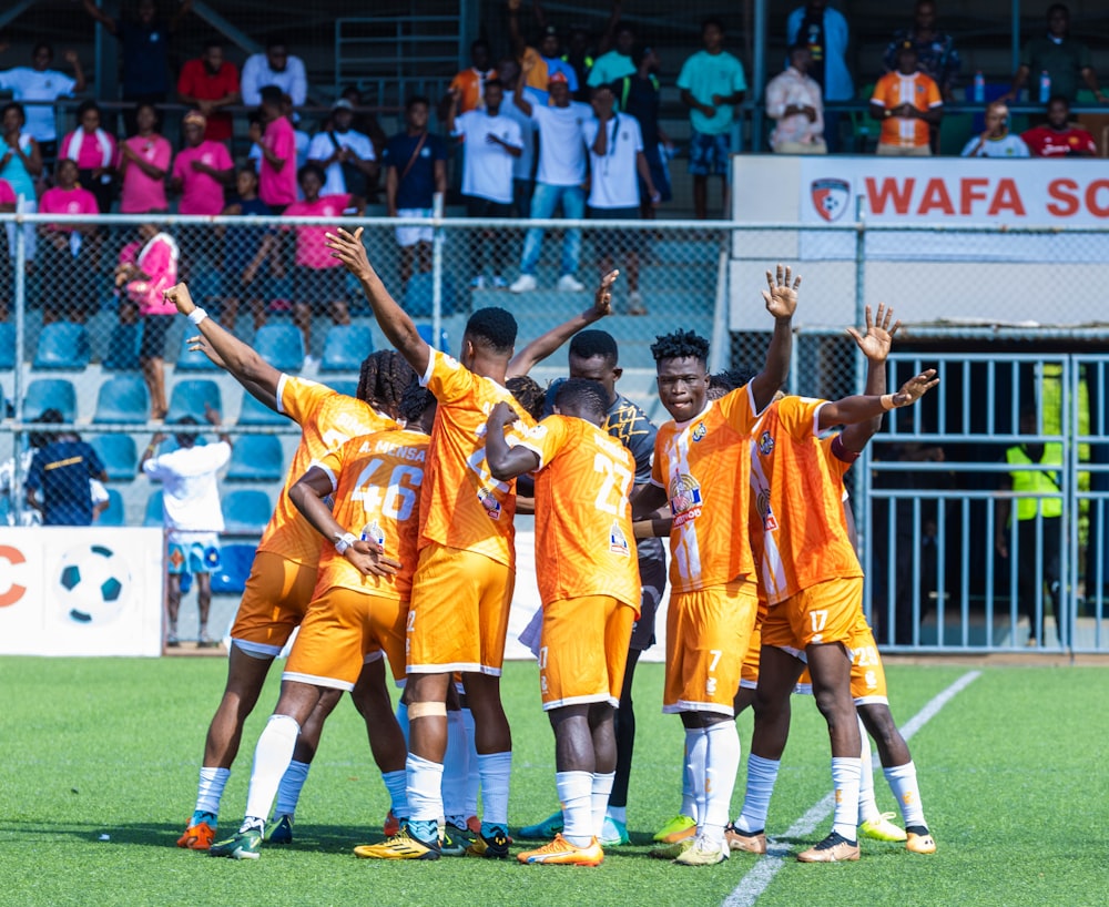 a group of young men standing on top of a soccer field