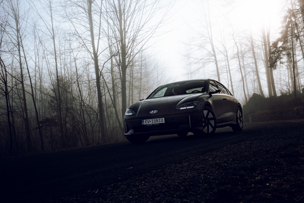 a car driving down a road in the woods