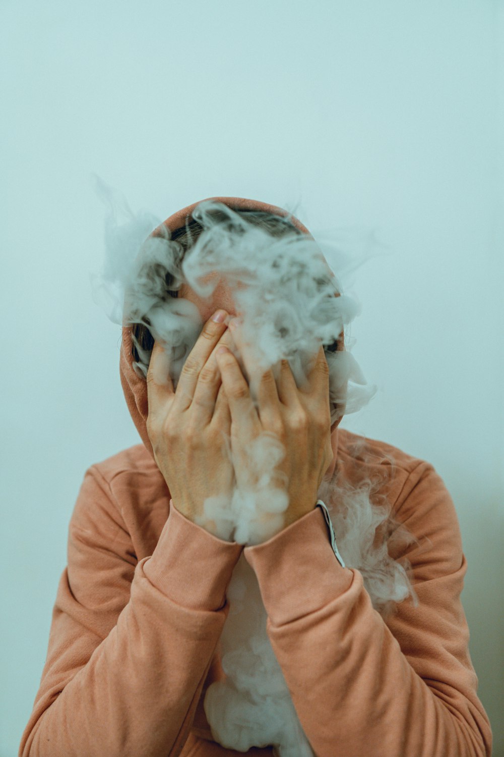 a woman covers her face with smoke