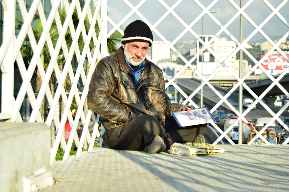 a man sitting on a ledge with a book