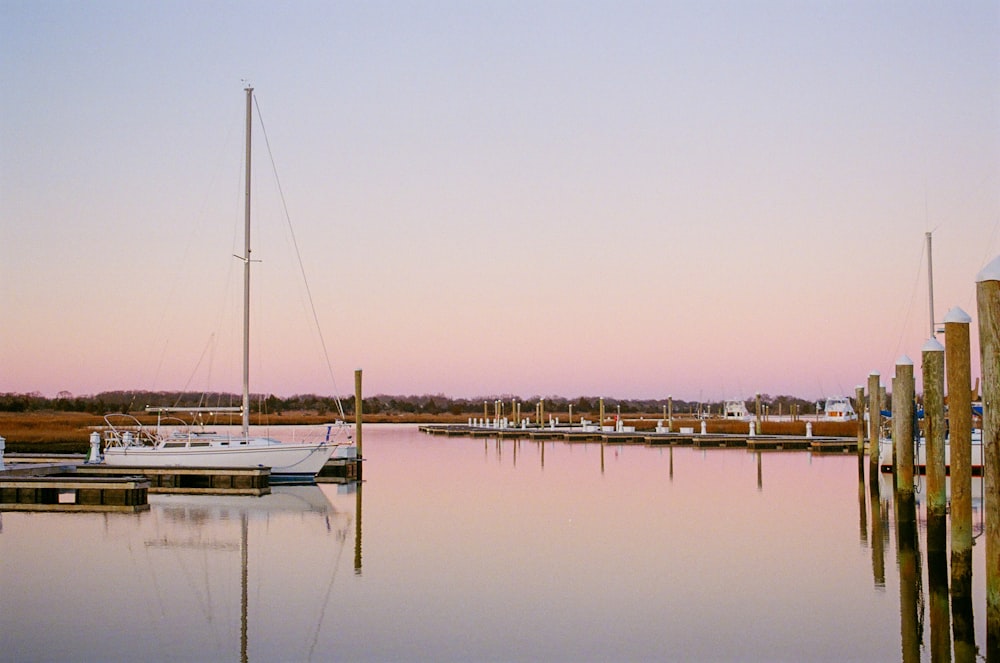 a sailboat is moored at a dock at sunset