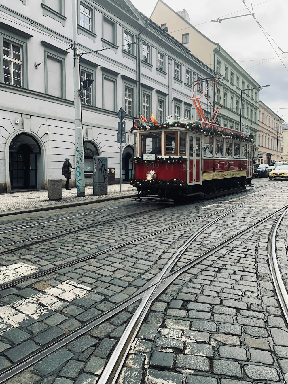 a trolley is traveling down a cobblestone street
