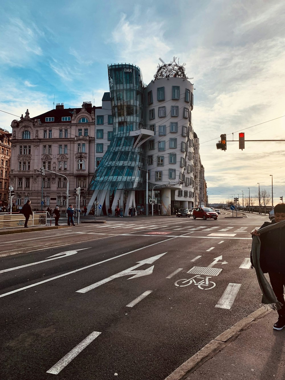 a man walking across a street next to a tall building