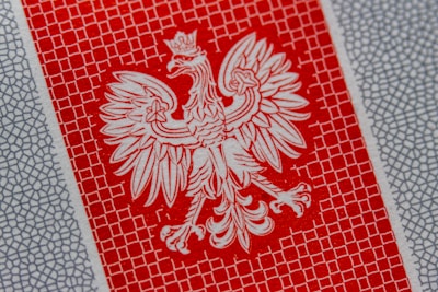 a close up of a red and white paper with a bird on it