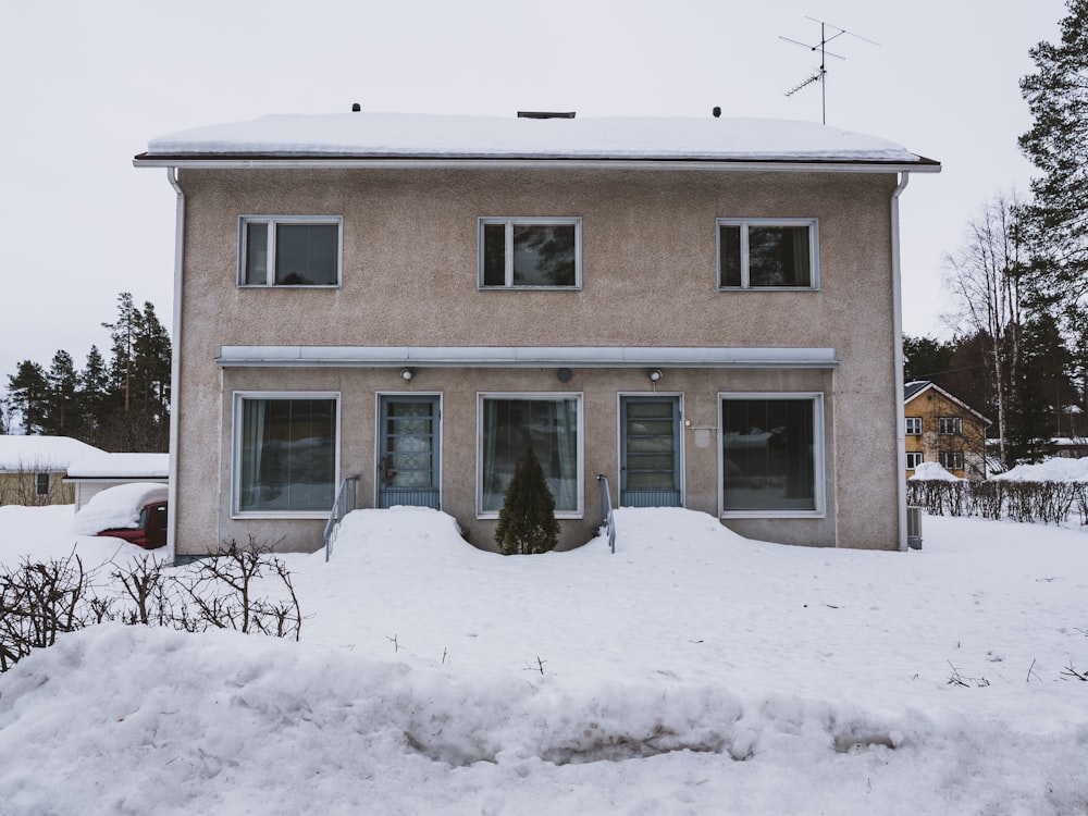 a house with snow on the ground in front of it