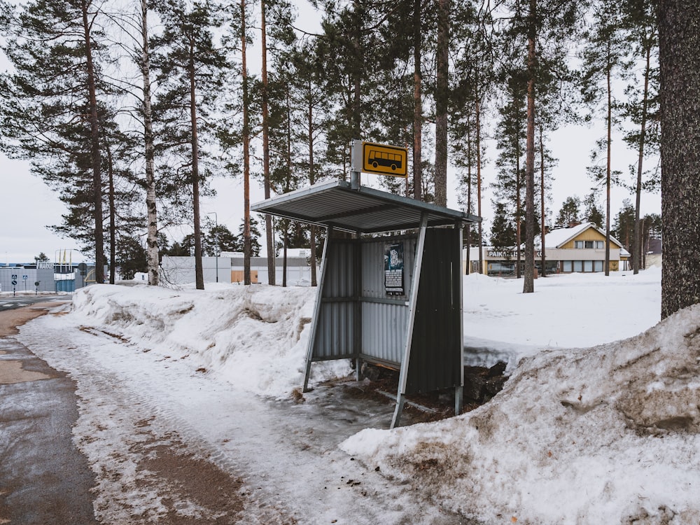 a small shelter in the middle of a snowy forest