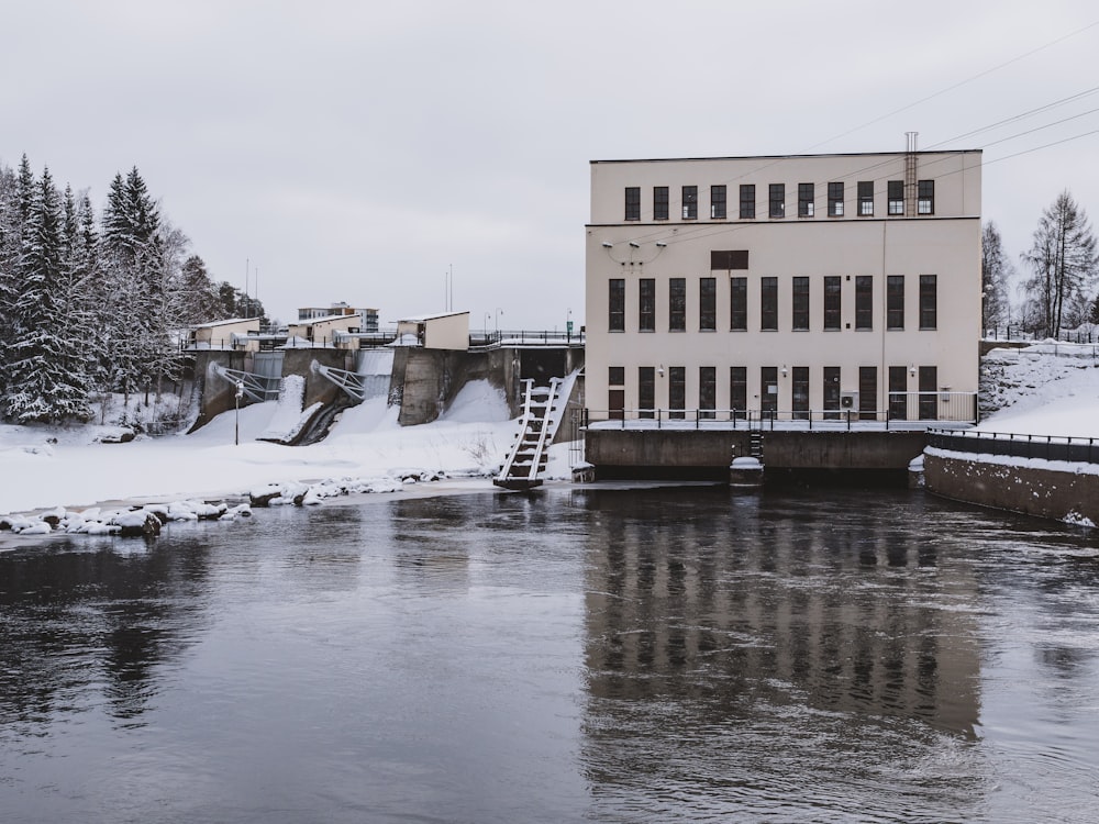 a building sitting on top of a river next to a bridge