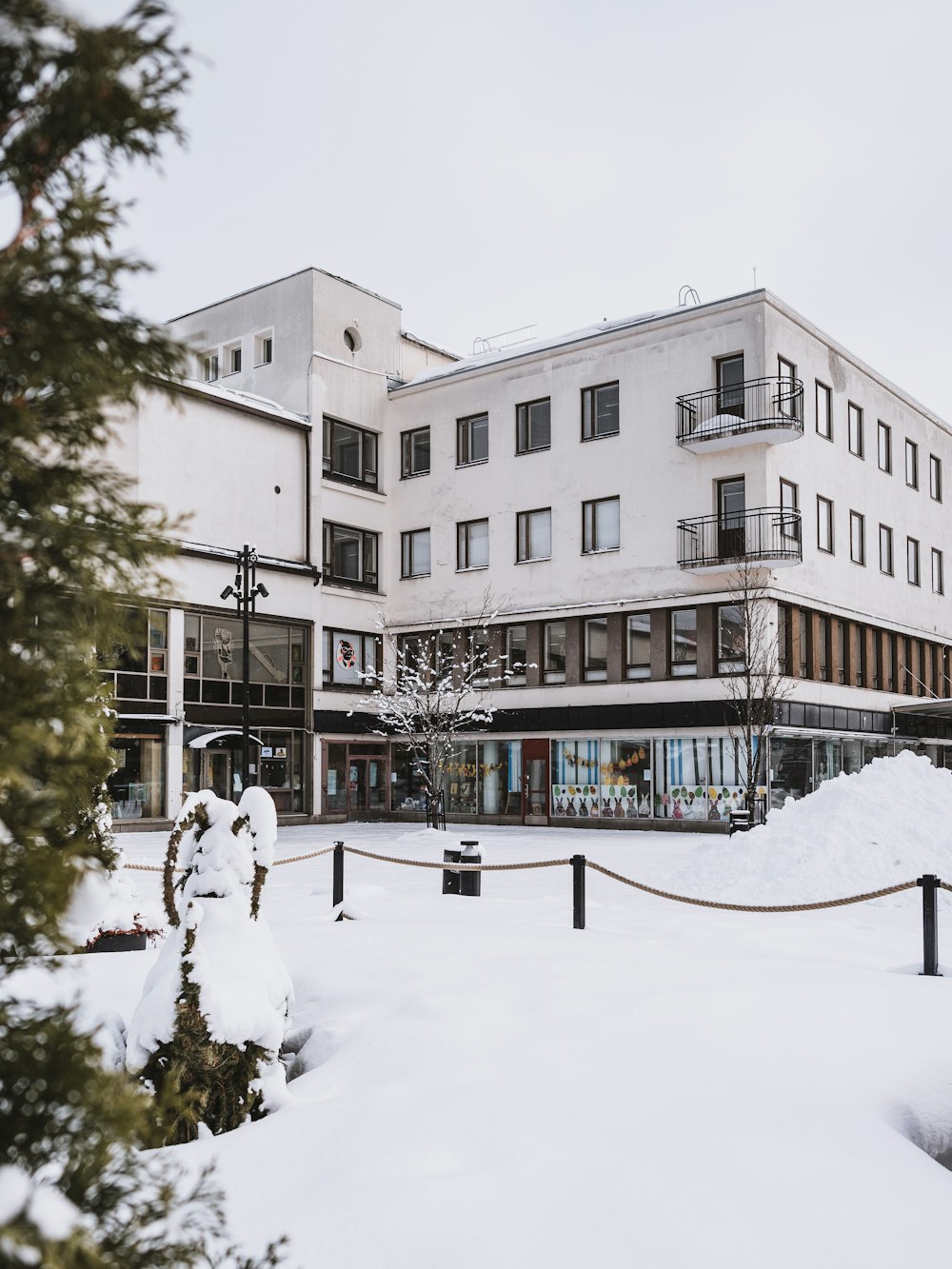 a snow covered street with a building in the background