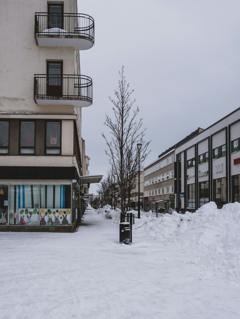 a snow covered street in front of a building