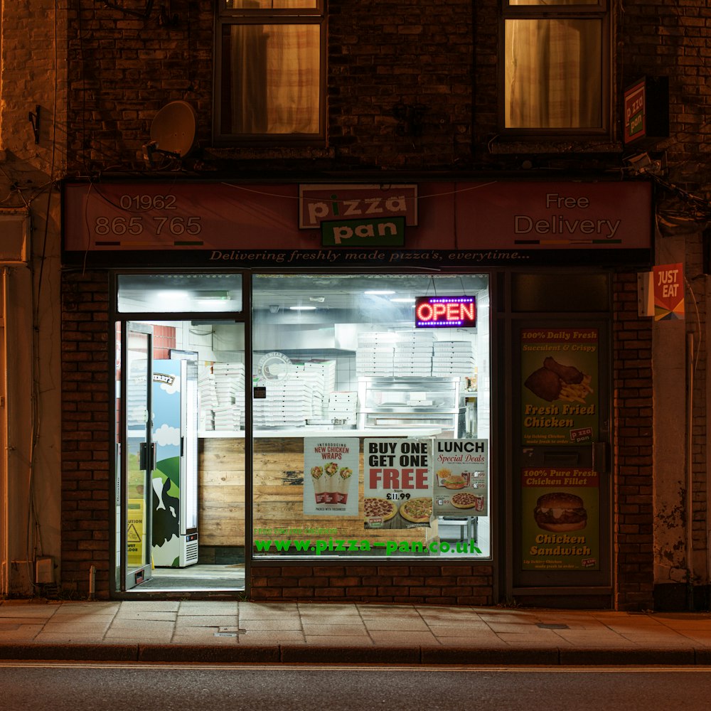 a store front with a lit up window at night