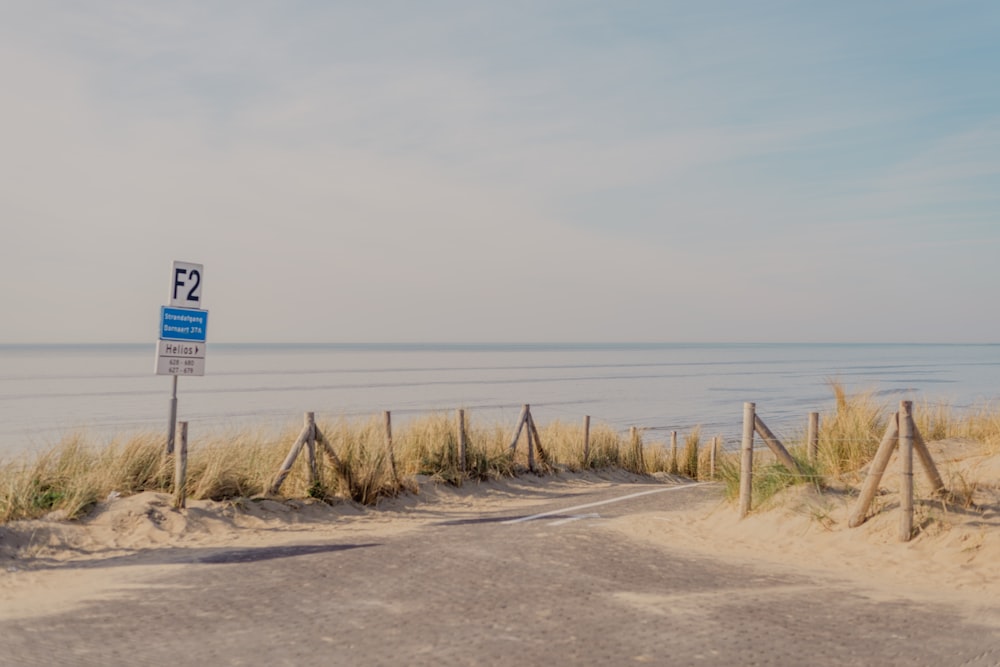 a street sign on the side of a road near the ocean