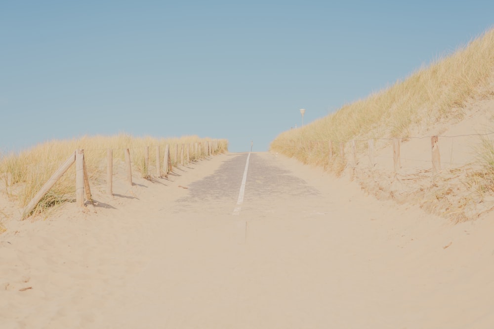 a sandy path leading to a sandy beach
