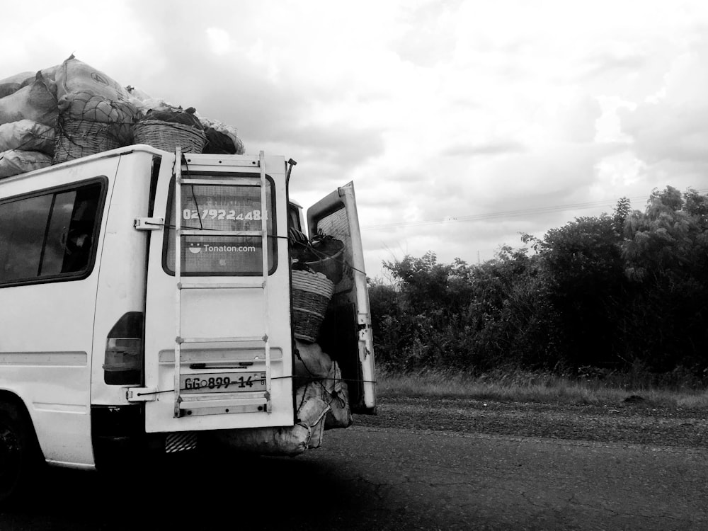 a black and white photo of a truck with bags on the back of it