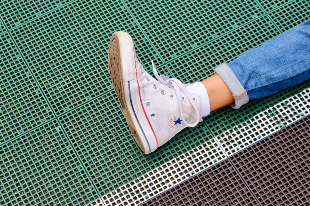 a person's feet resting on a green mat