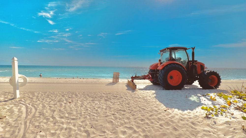 a tractor parked on a beach next to the ocean