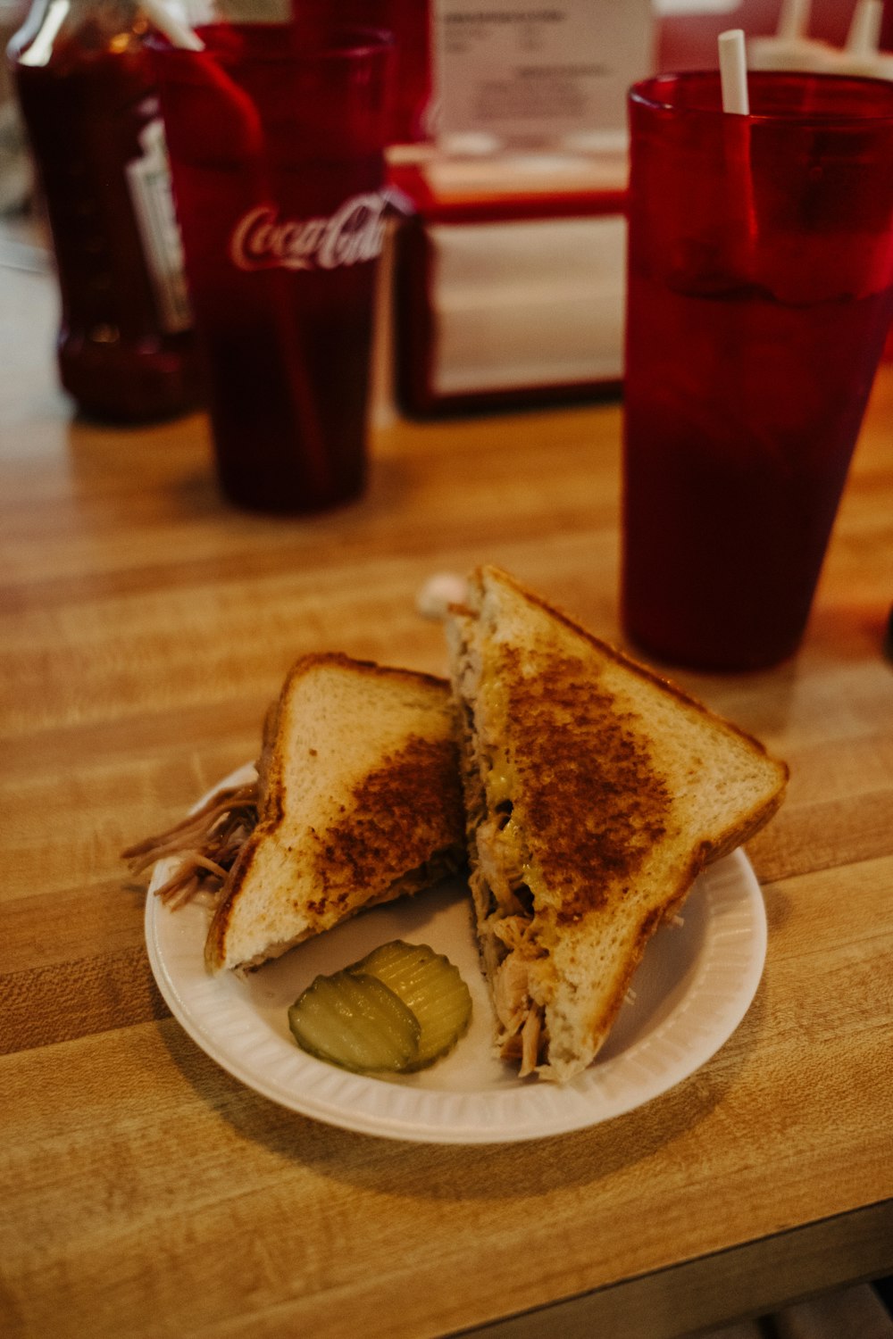 a sandwich on a plate with pickles on the side