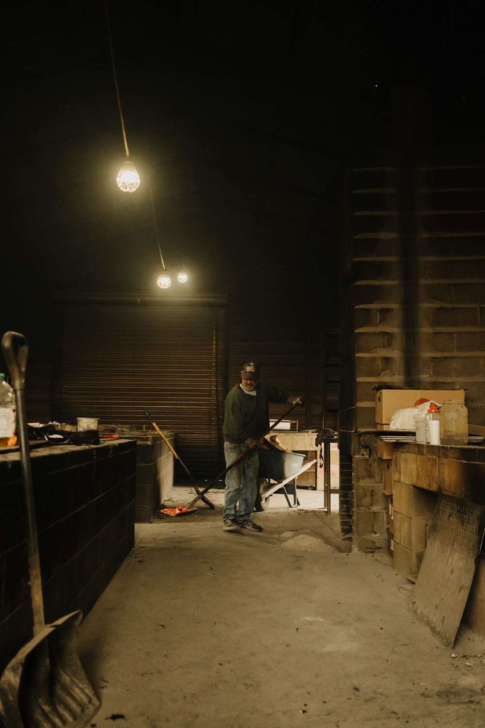 a man standing in a dark room with a shovel