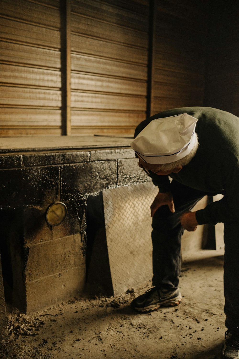 a man bending over in front of a fire place