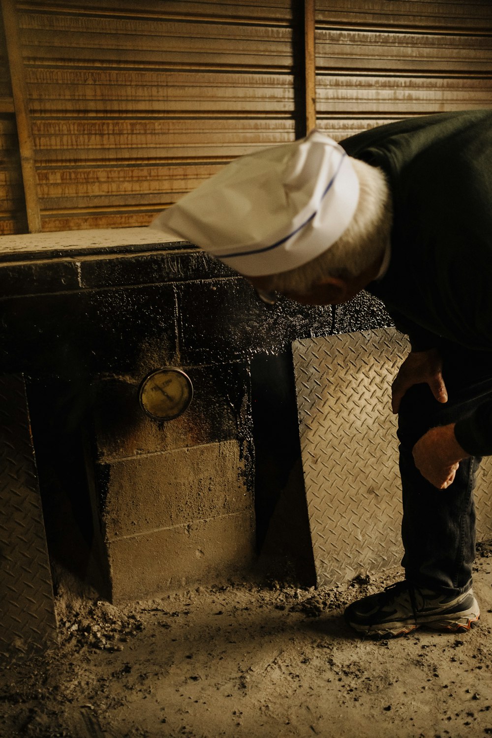 a man bending over to look at a piece of wood