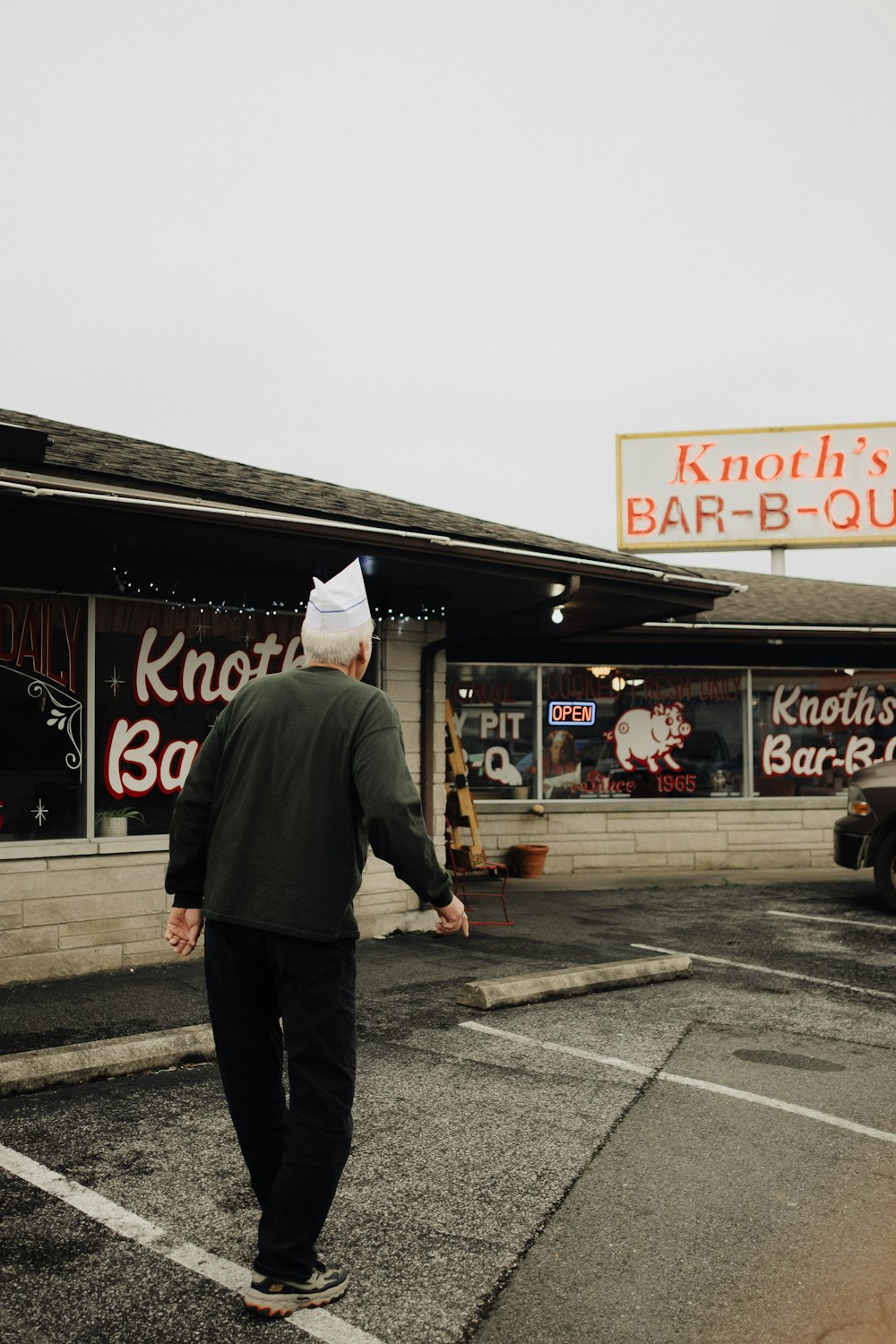 a man walking down the street in front of a bar