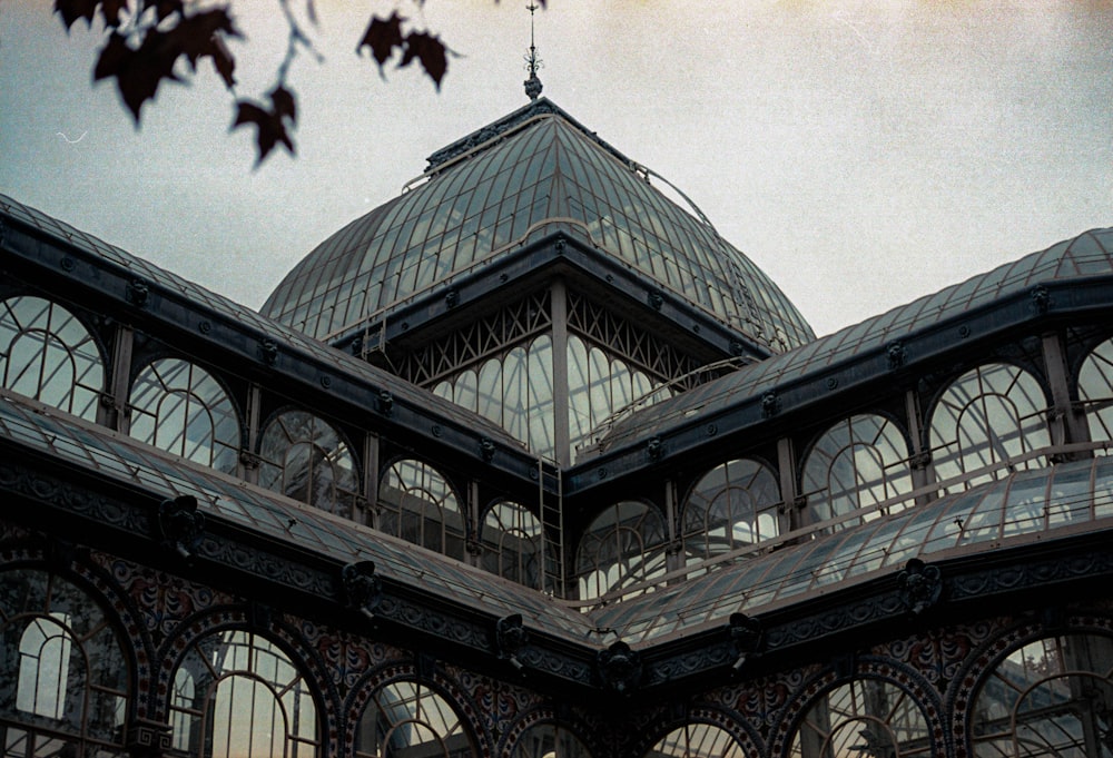 a large glass building with a clock on the top of it