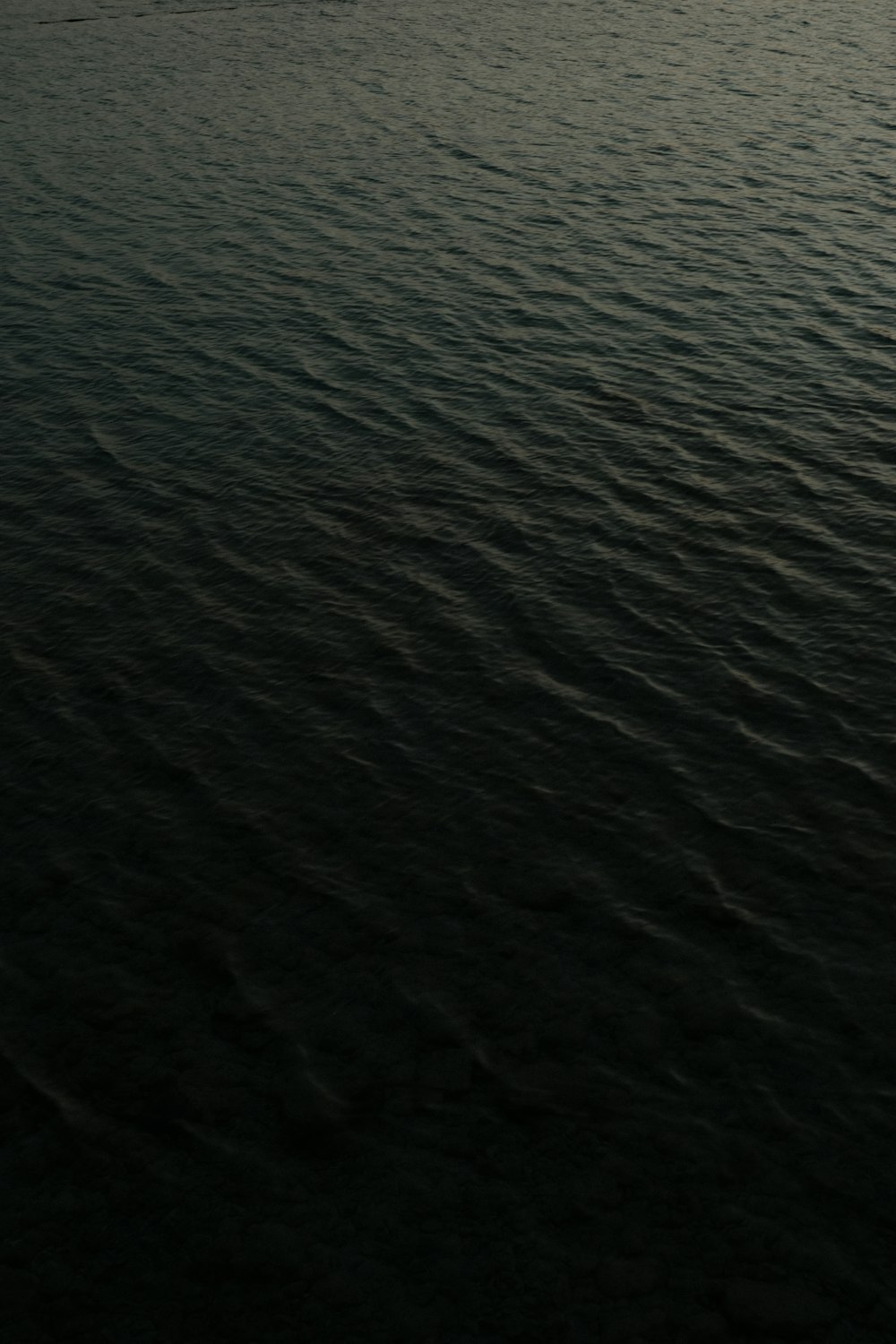 a large body of water with a boat in the distance