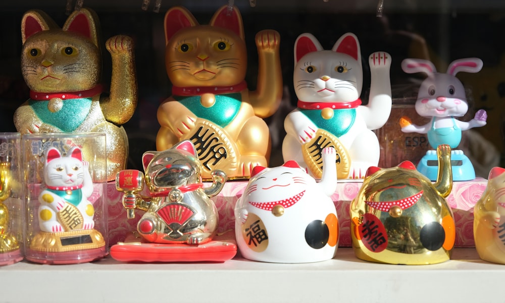 a group of cat figurines sitting on top of a shelf