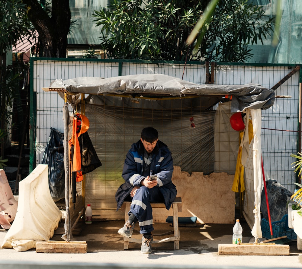 a man sitting on a bench looking at his cell phone