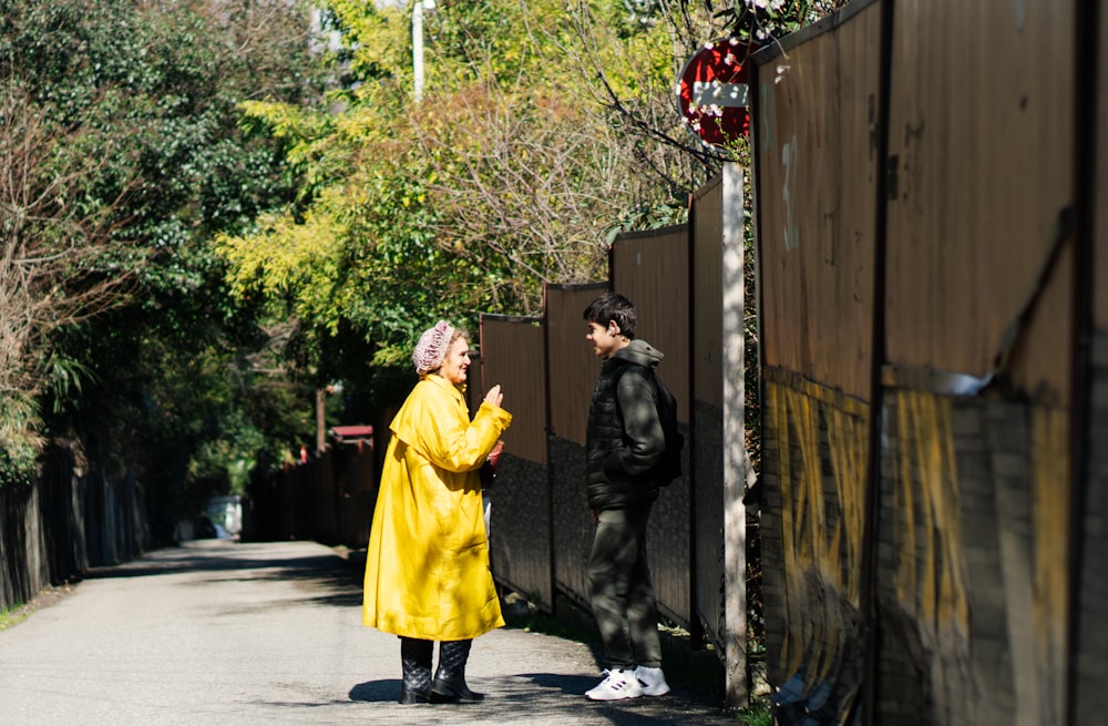 a woman in a yellow coat standing next to a man