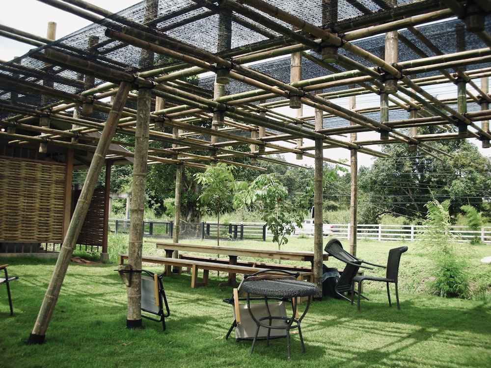 a picnic table and chairs under a wooden structure