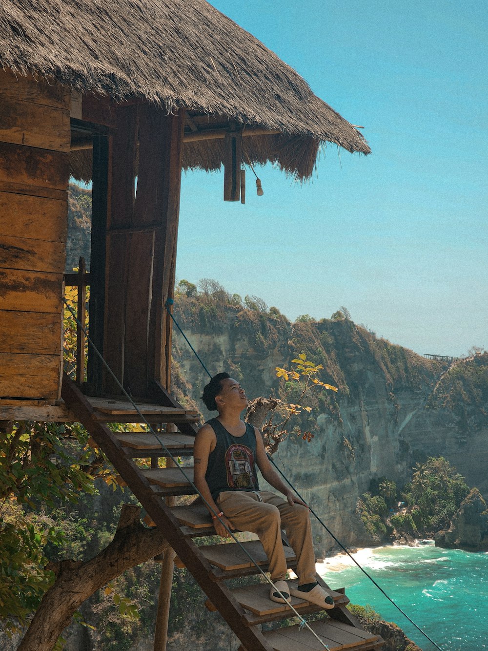 a man sitting on top of a wooden staircase