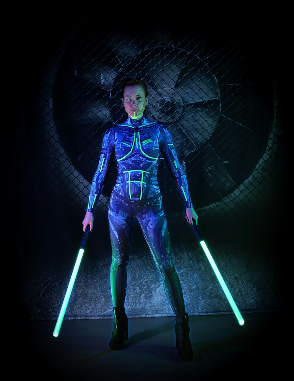 a woman in a blue space suit holding two lights