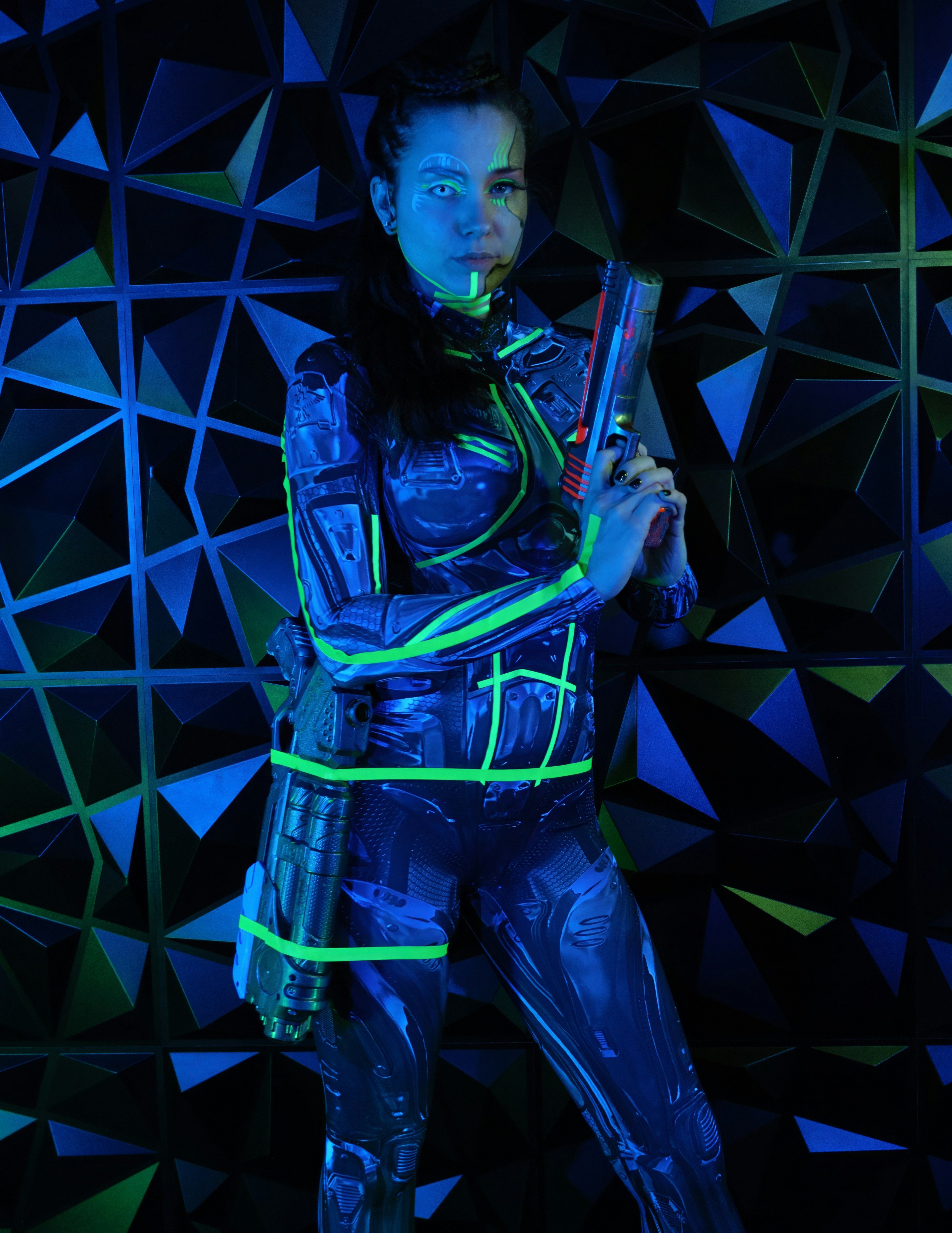 seorang wanita berjas futuristik memegang pistol