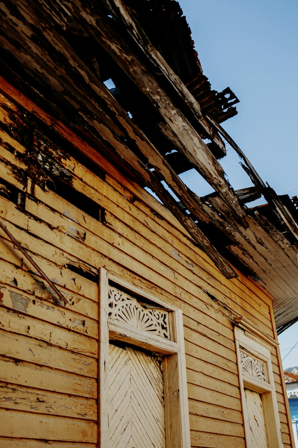 an old wooden building with a broken roof