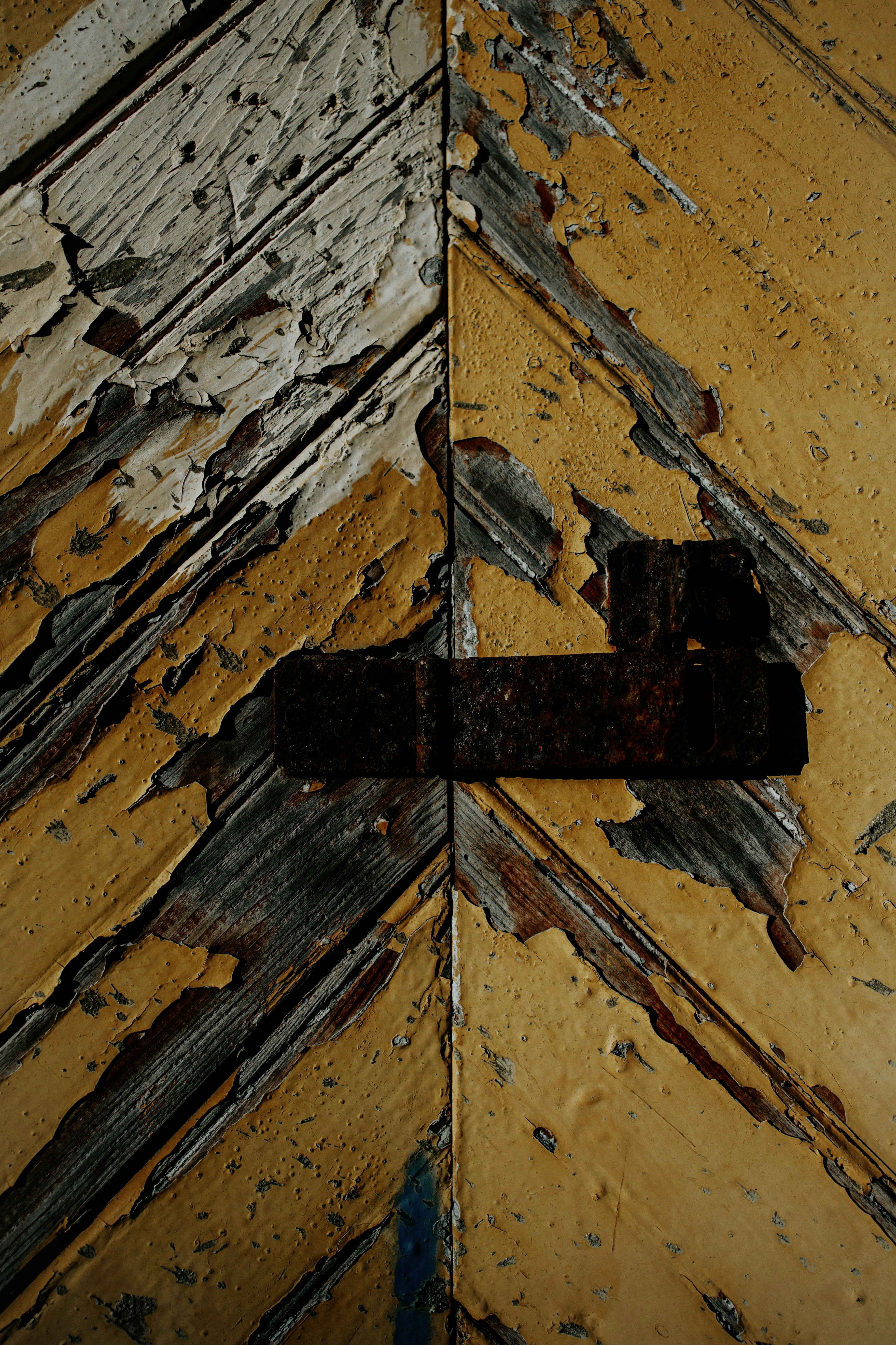 una cruz de metal oxidado en el costado de un edificio