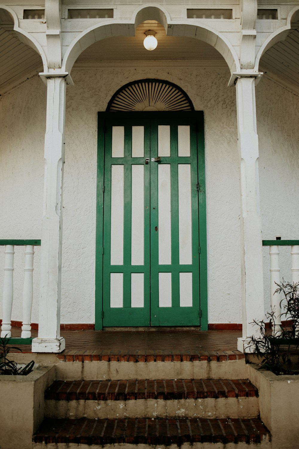 a green door on the side of a white building