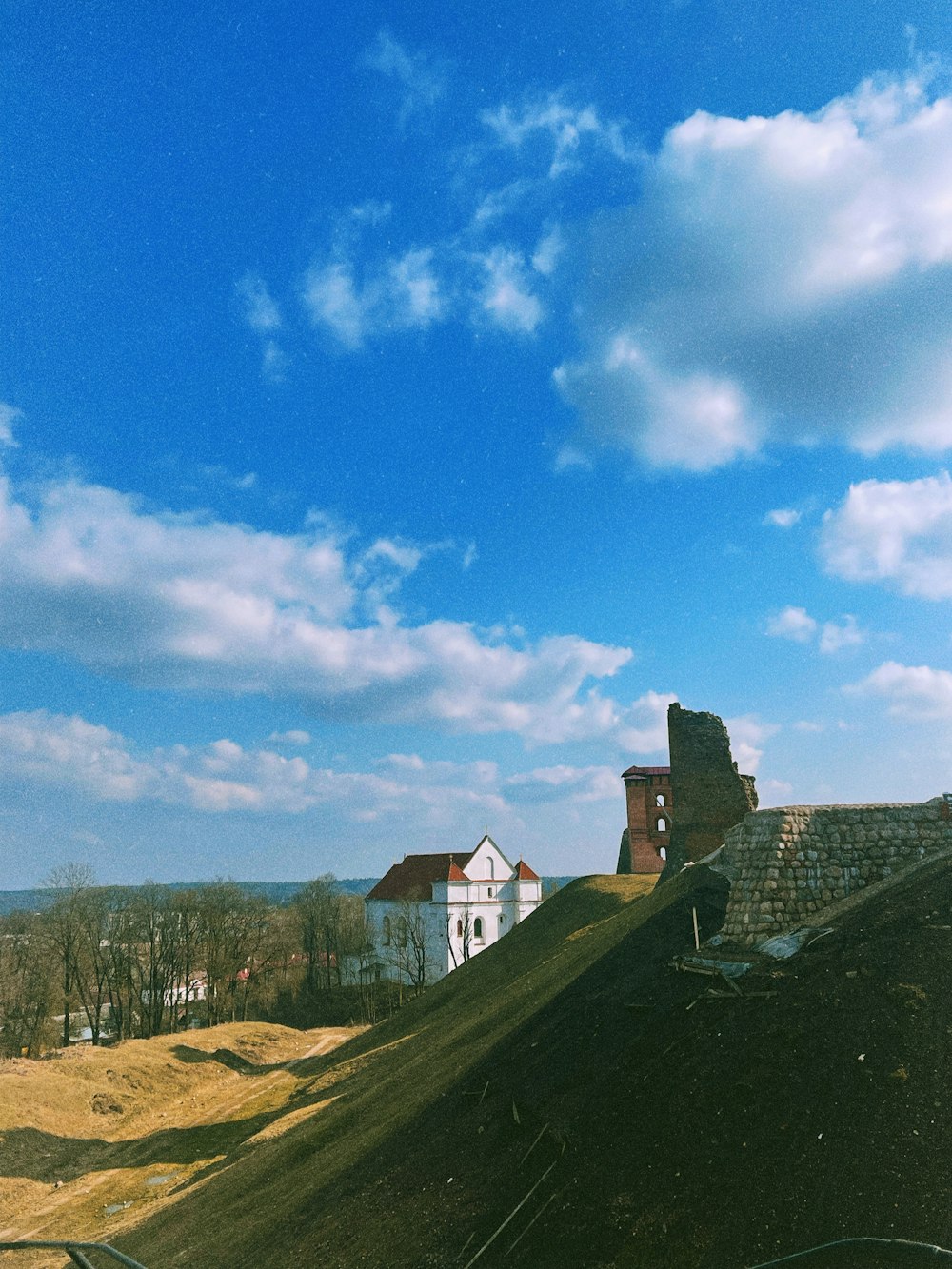 a house on a hill with a blue sky in the background