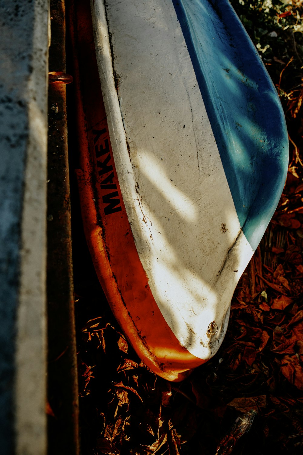 a surfboard laying on the ground next to a wall