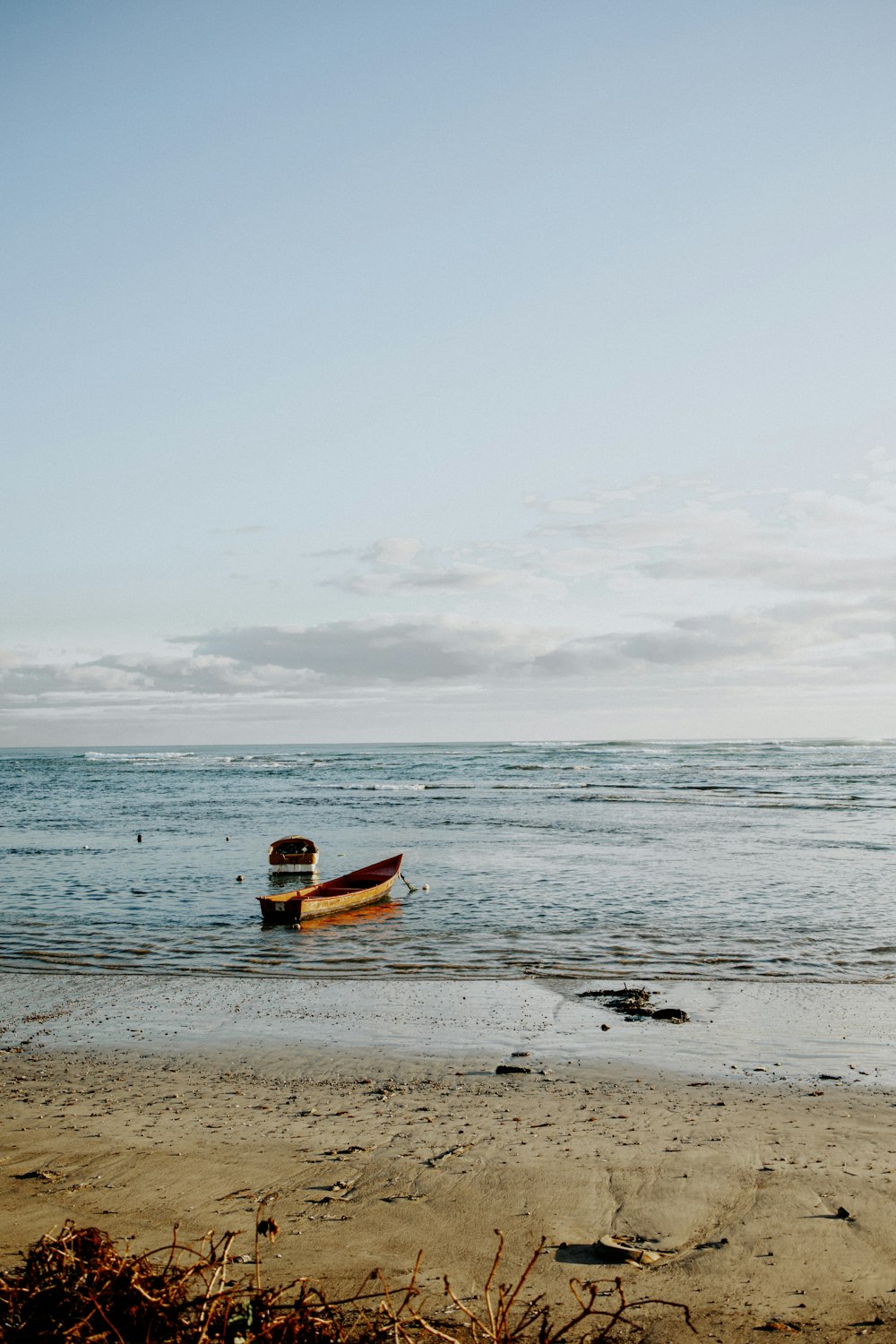 a small boat sitting on top of a sandy beach