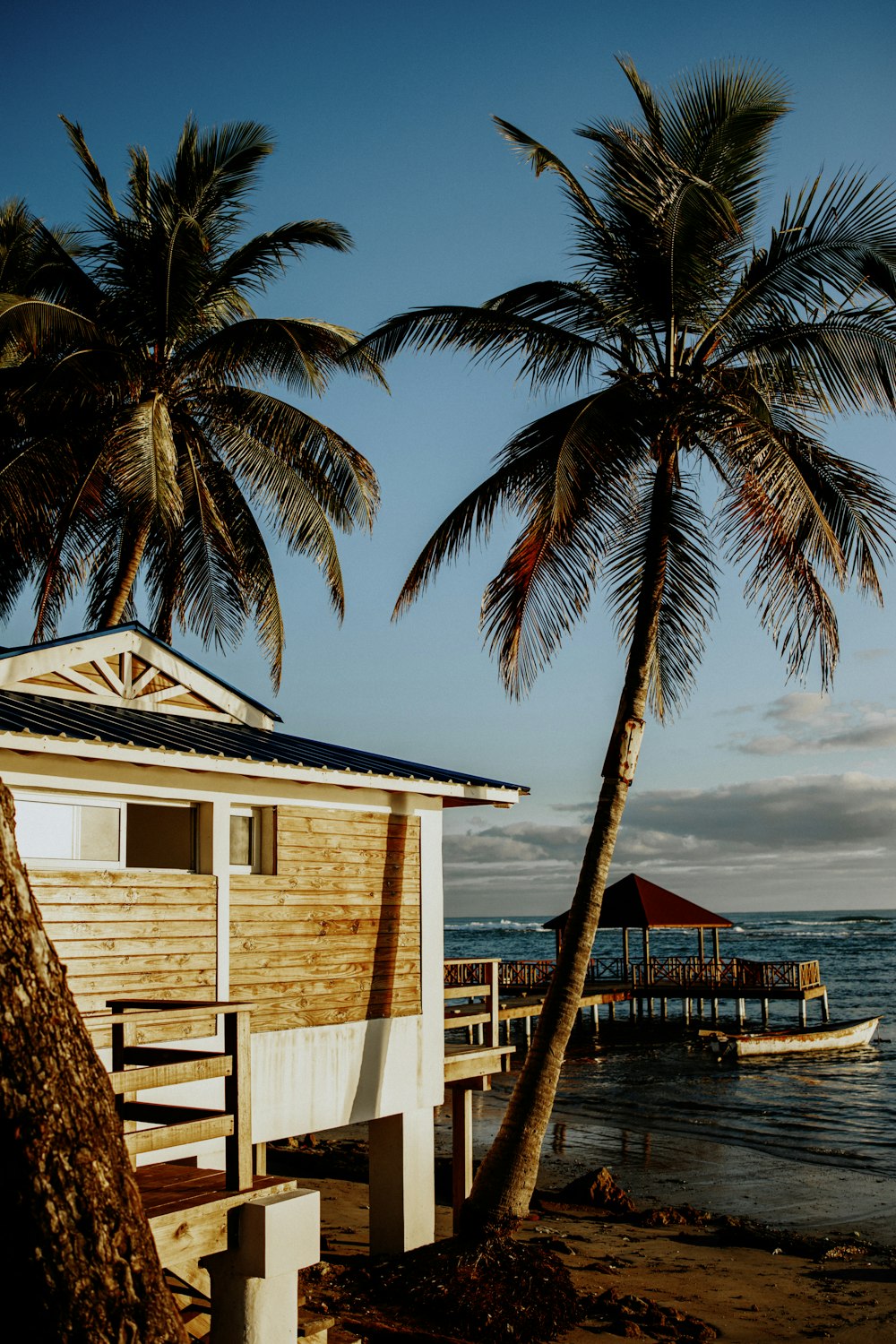 a small wooden house sitting on top of a beach next to the ocean