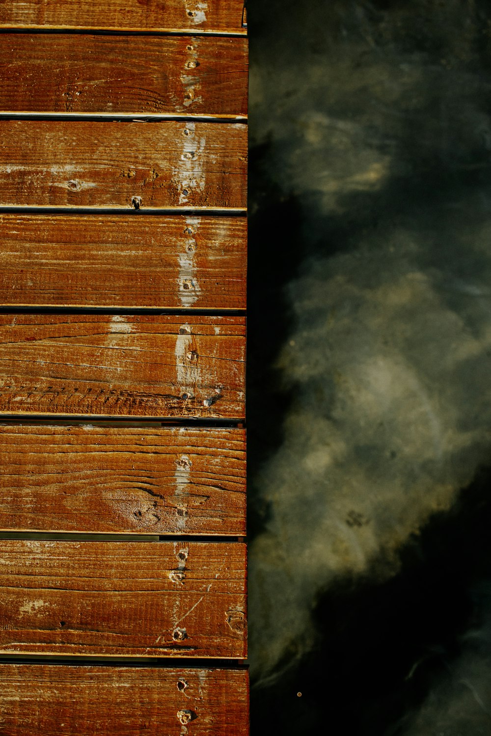 un primo piano di un molo di legno con acqua