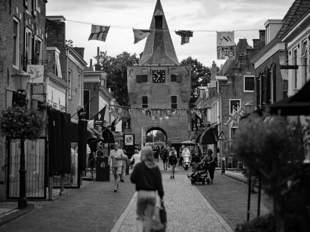 a black and white photo of people walking down a street